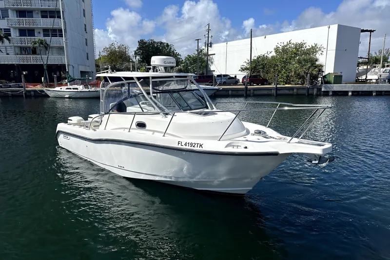 Slide: The Image of 2006 Boston Whaler 285 Conquest boat docked in a marina under a clear blue sky. - 33