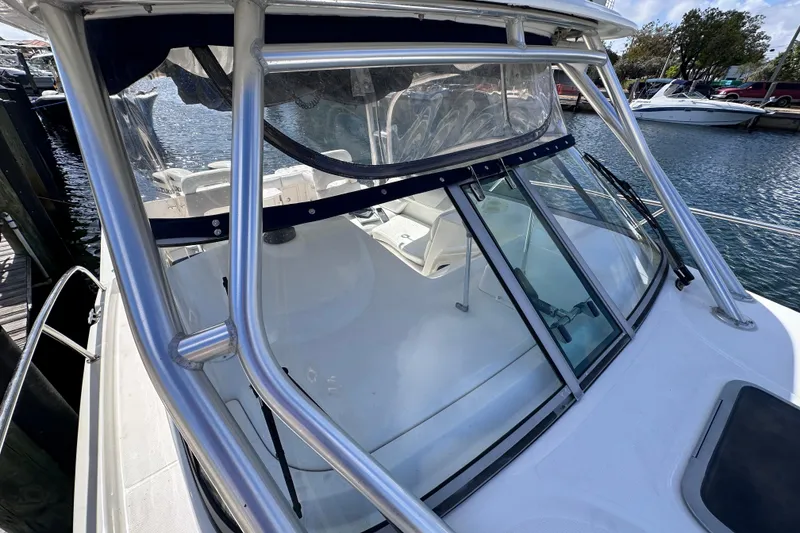 Slide: The Image of 2006 Boston Whaler 285 Conquest boat docked, featuring a sleek windshield and sturdy frame. - 39