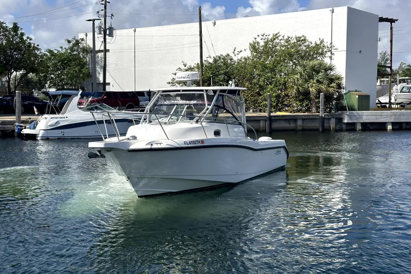 Slide: The Image of 2006 Boston Whaler 285 Conquest boat docked in a marina, clear sky background. - 4