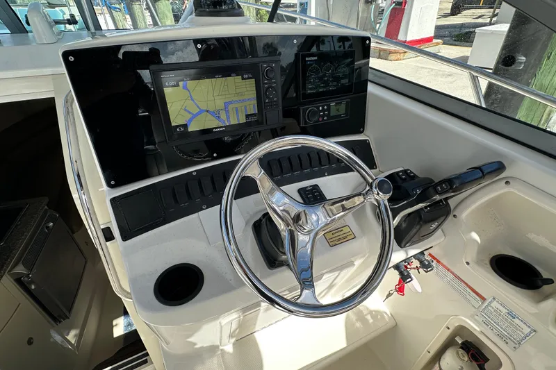 Slide: The Image of 2006 Boston Whaler 285 Conquest helm with navigation system and steering wheel. - 64
