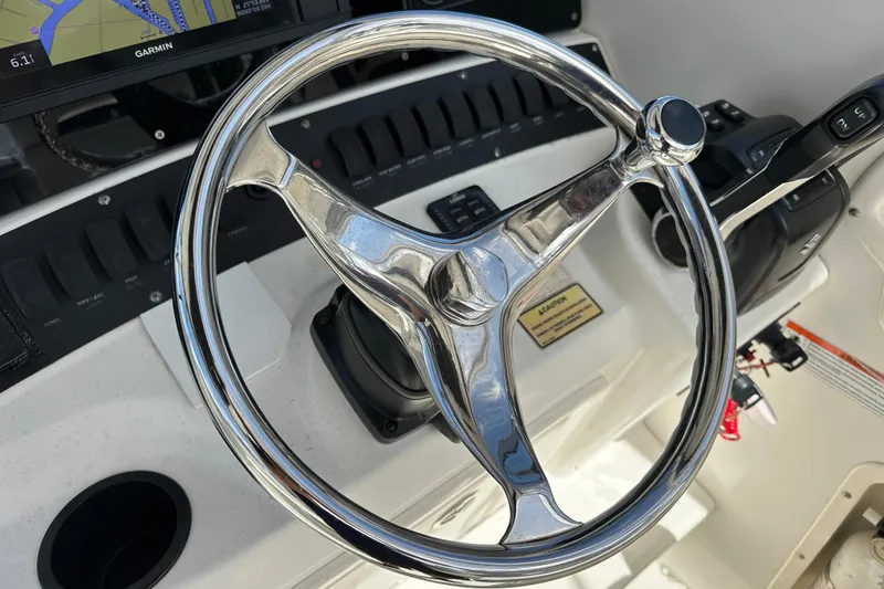 Slide: The Image of Steering wheel of a 2006 Boston Whaler 285 Conquest boat with navigation display. - 69