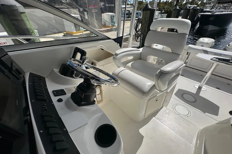 Slide: The Image of 2006 Boston Whaler 285 Conquest helm with steering wheel and captain's chair. - 73
