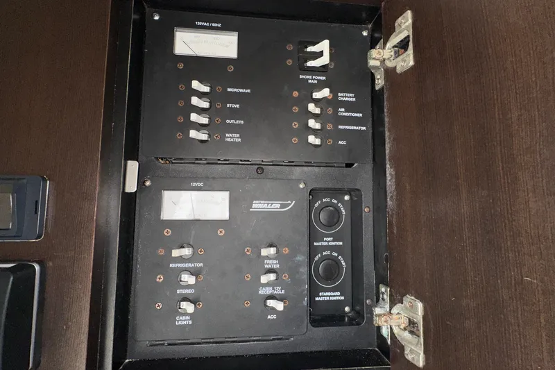 Slide: The Image of Electrical panel of a 2006 Boston Whaler 285 Conquest boat, showing switches and meters. - 81