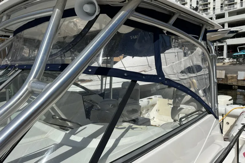 Slide: The Image of 2006 Boston Whaler 285 Conquest boat with clear canopy and sturdy metal frame. - 93