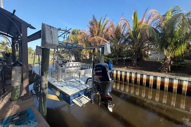 Slide: The Image of 2007 Pathfinder 2200 Tournament Edition boat docked by palm trees in a canal. - 14