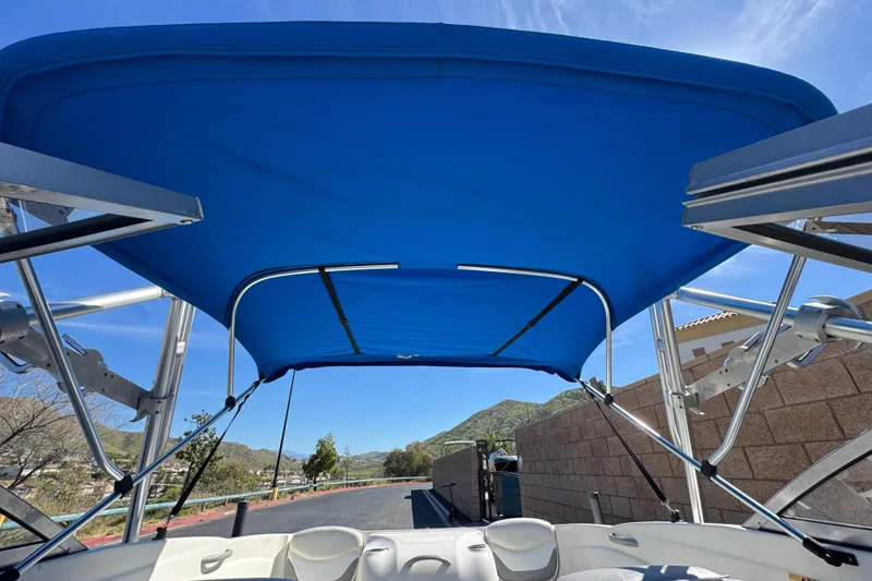 Slide: The Image of 2006 Bayliner 175 XT boat with blue canopy, scenic mountain view. - 13