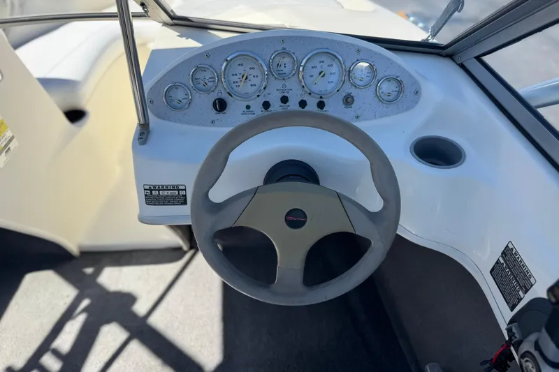 Slide: The Image of Steering wheel and dashboard of 2006 Bayliner 175 XT boat, featuring gauges and controls. - 22