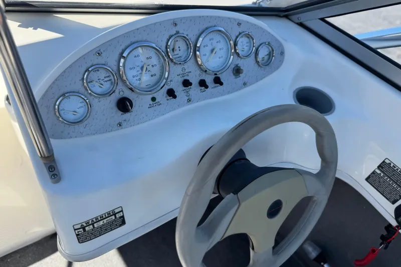 Slide: The Image of Dashboard of a 2006 Bayliner 175 XT boat with gauges and steering wheel. - 23