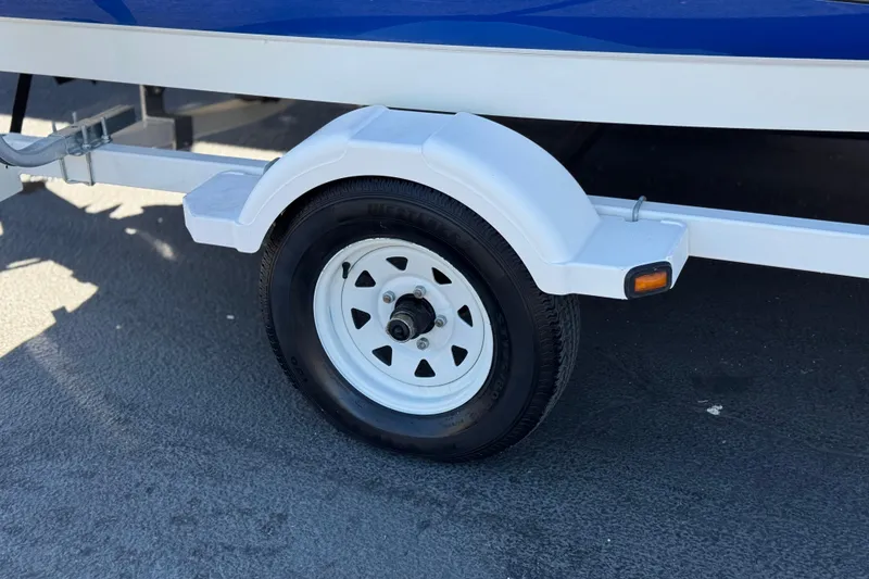 Slide: The Image of Trailer wheel of 2006 Bayliner 175 XT boat on pavement. - 26
