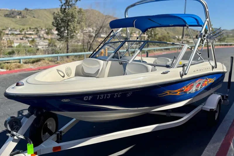 Slide: The Image of 2006 Bayliner 175 XT boat with blue hull and custom graphics on a trailer. - 3