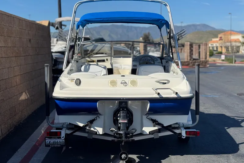 Slide: The Image of 2006 Bayliner 175 XT boat with blue canopy, parked on a trailer. - 4