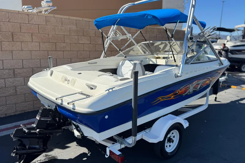 Slide: The Image of 2006 Bayliner 175 XT boat with blue canopy and trailer, parked outdoors. - 5