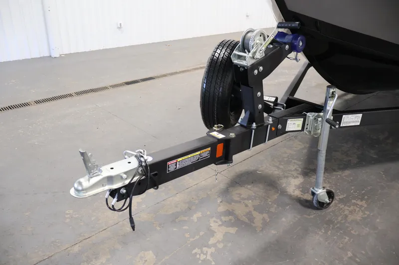 Slide: The Image of 2024 Lowe Fishing Machine 1775WT trailer hitch and wheel assembly in a garage setting. - 44