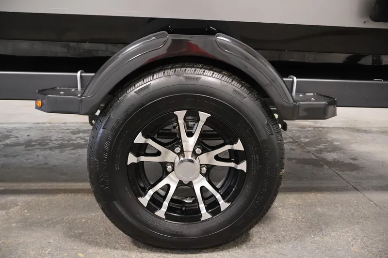 Slide: The Image of 2024 Lowe Fishing Machine 1775WT trailer wheel with sleek black and silver rim design. - 47