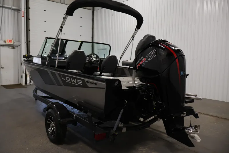 Slide: The Image of 2024 Lowe Fishing Machine 1775WT boat with powerful outboard motor in a garage setting. - 7