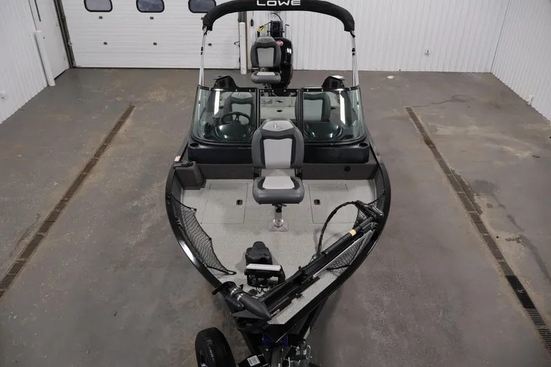 Slide: The Image of 2024 Lowe Fishing Machine 1775WT in a garage, showcasing seating and fishing equipment. - 9