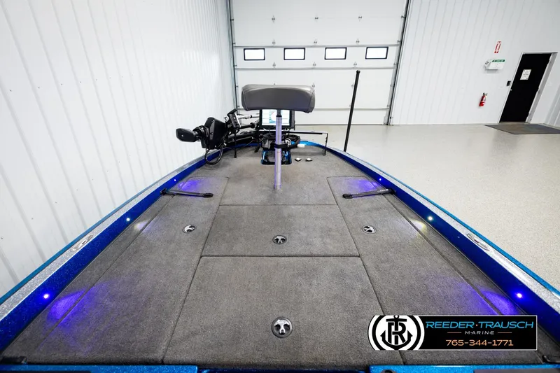 Slide: The Image of 2008 Triton 20X2 DC boat interior with gray carpet and blue accents in a showroom. - 14