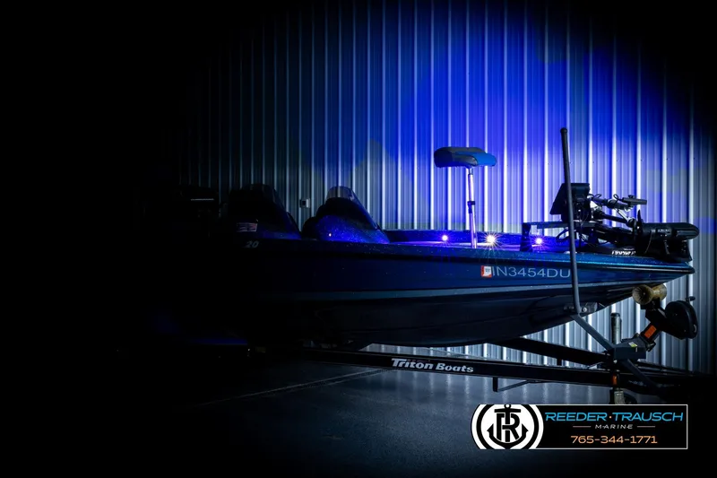 Slide: The Image of 2008 Triton 20X2 DC boat in dimly lit showroom with blue lighting. - 3
