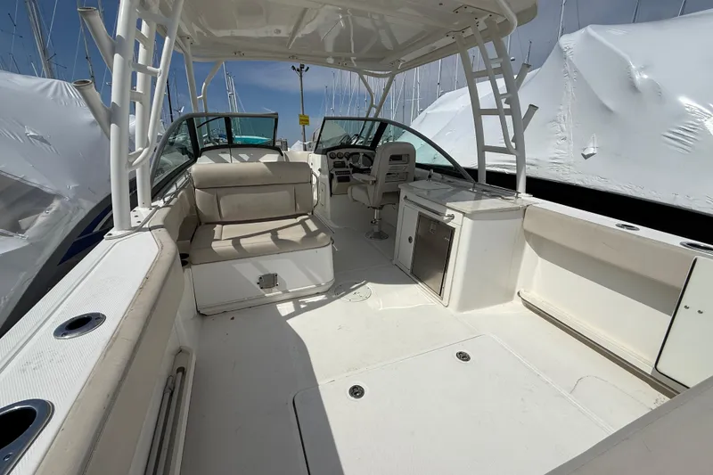 Slide: The Image of 2016 Boston Whaler 270 Vantage boat interior with seating and helm, docked under clear skies. - 17