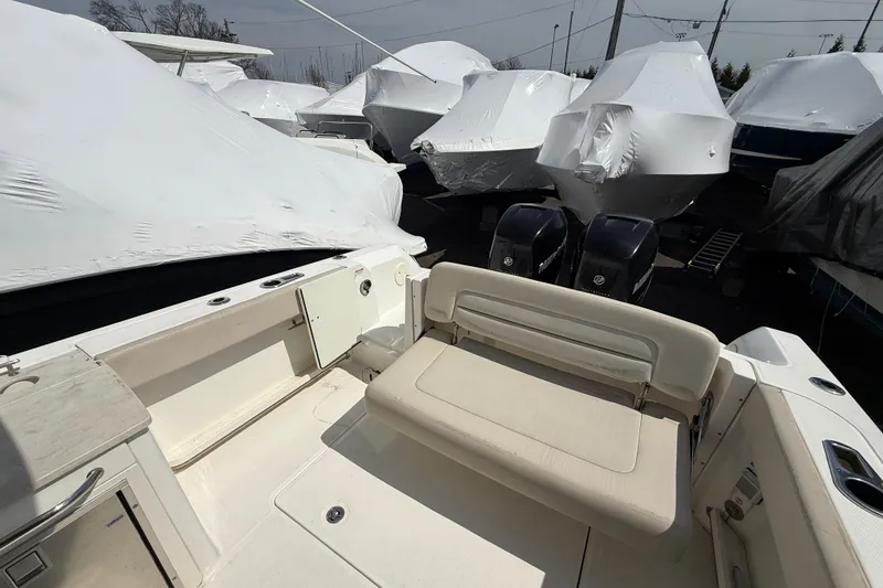 Slide: The Image of 2016 Boston Whaler 270 Vantage boat interior with covered vessels in background. - 21