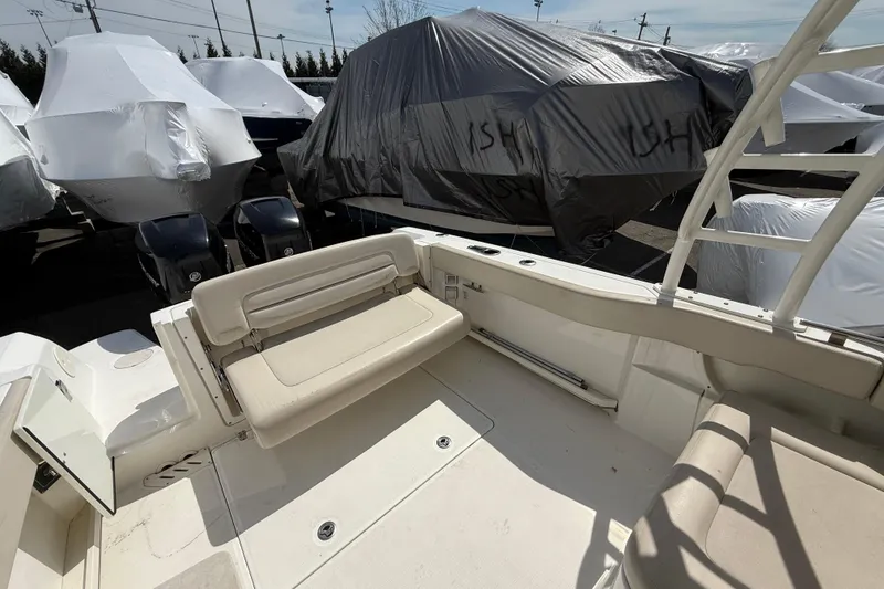 Slide: The Image of 2016 Boston Whaler 270 Vantage boat interior with seating, surrounded by covered boats. - 22