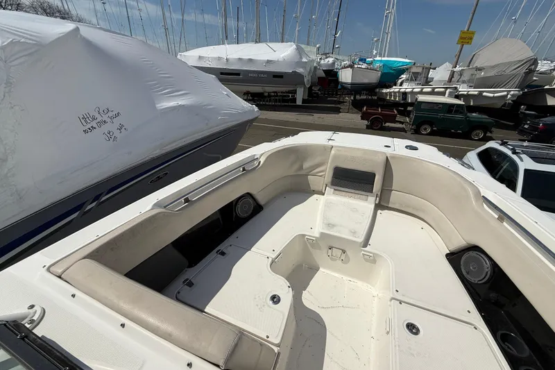 Slide: The Image of 2016 Boston Whaler 270 Vantage boat interior, docked with other covered boats nearby. - 33
