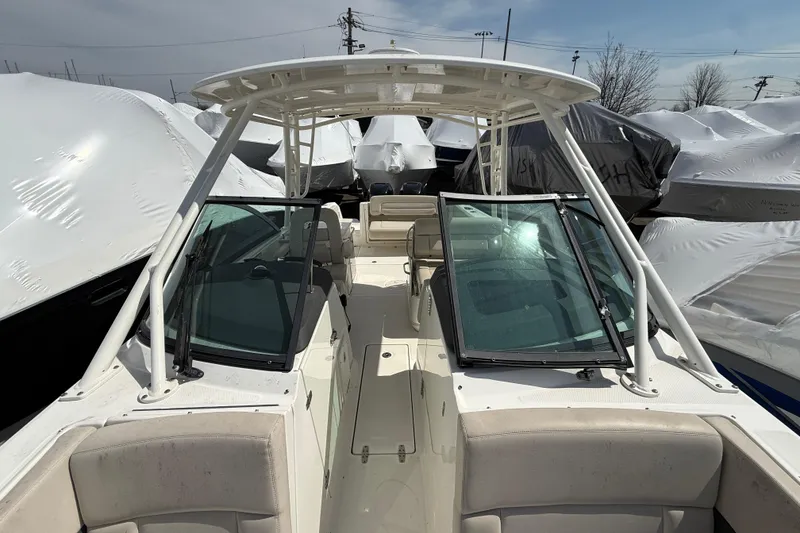 Slide: The Image of 2016 Boston Whaler 270 Vantage boat, docked with protective covers, under clear sky. - 34