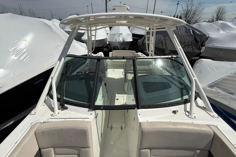 Slide: The Image of 2016 Boston Whaler 270 Vantage boat, docked and covered, showcasing spacious seating and windshield. - 35