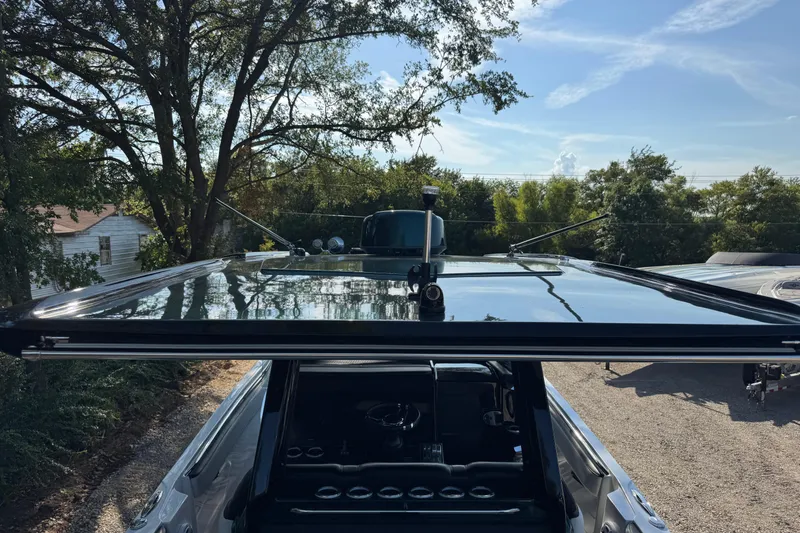 Slide: The Image of 2024 Nor-Tech 400 Supersport boat with open sunroof, surrounded by trees and clear sky. - 8