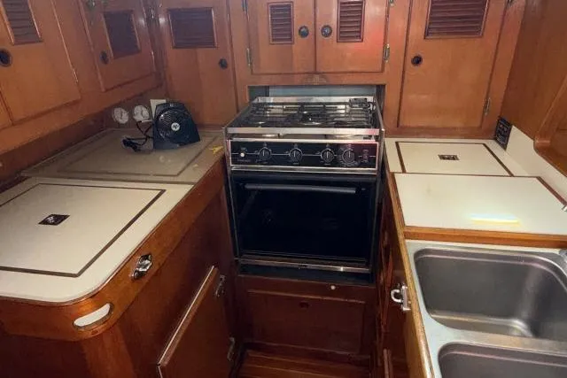 Slide: The Image of 1980 Mao Ta Skye 51 yacht kitchen with stove, sink, and wooden cabinetry. - 10