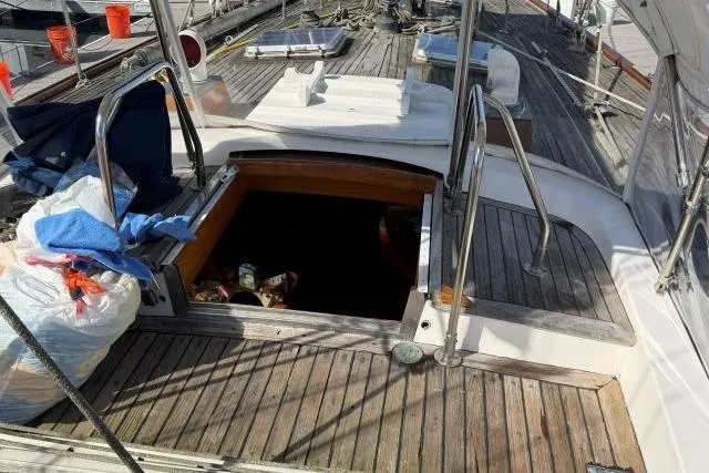 Slide: The Image of 1980 Mao Ta Skye 51 sailboat deck with open hatch and scattered items. - 49