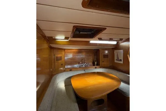 Slide: The Image of Interior of 1980 Mao Ta Skye 51 yacht with wooden dining area and cozy seating. - 6