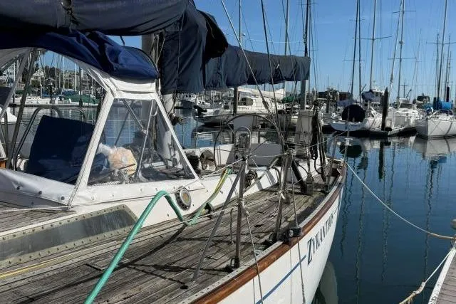 Slide: The Image of Sailboat Mao Ta Skye 51, 1980 model, docked in a marina with clear blue skies. - 69