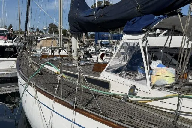 Slide: The Image of 1980 Mao Ta Skye 51 sailboat docked at marina with wooden deck and covered cockpit. - 71