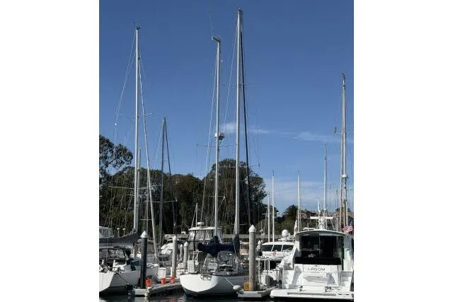 Slide: The Image of Sailboats docked at a marina, featuring a 1980 Mao Ta Skye 51 under clear blue skies. - 77