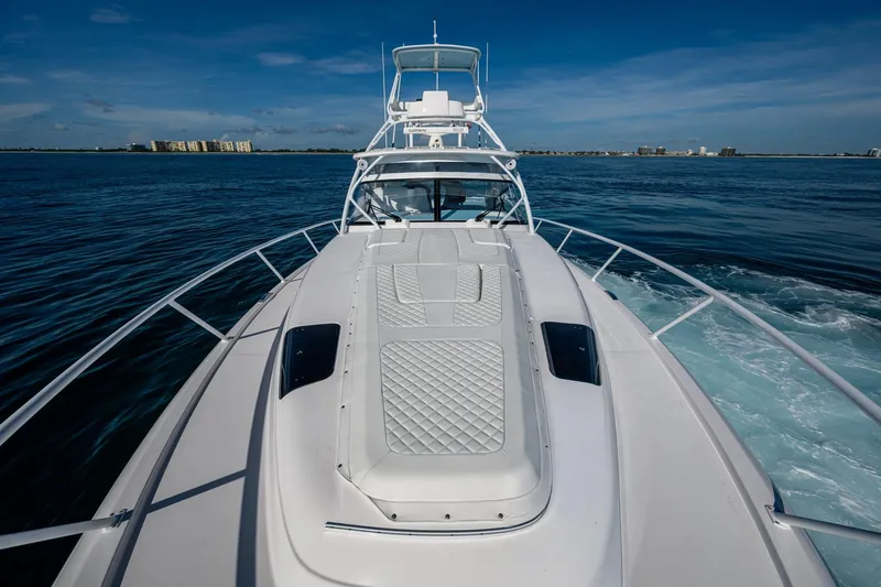 Slide: The Image of 2023 Intrepid 477 Evolution yacht cruising on open water under clear skies. - 14