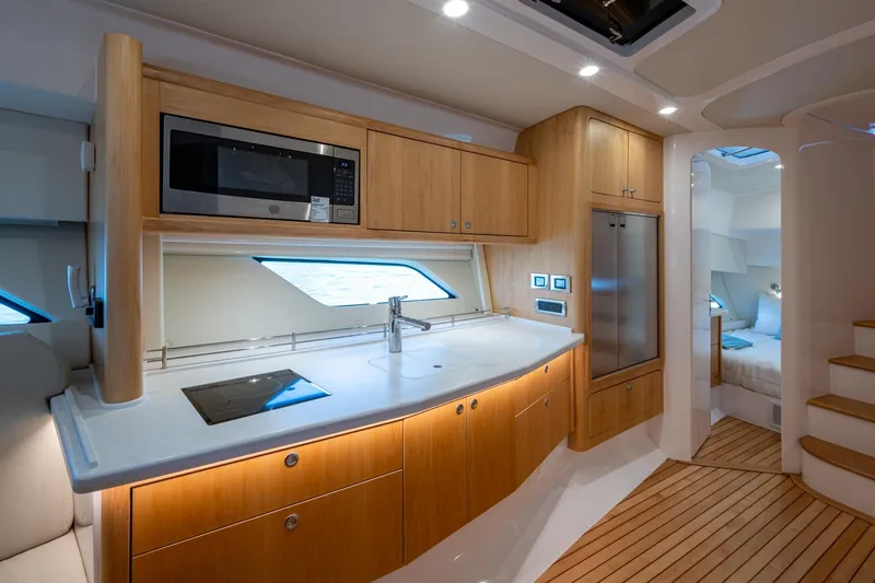 Slide: The Image of Luxurious 2023 Intrepid 477 Evolution yacht interior with modern kitchen and cozy bedroom. - 22