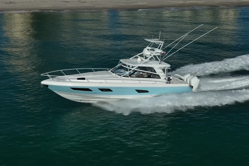 Slide: The Image of 2023 Intrepid 477 Evolution cruising on the ocean near the shore. - 3