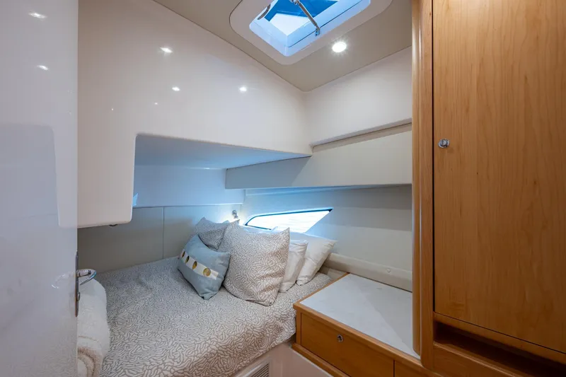 Slide: The Image of Cozy cabin interior of 2023 Intrepid 477 Evolution yacht with bed and skylight. - 31