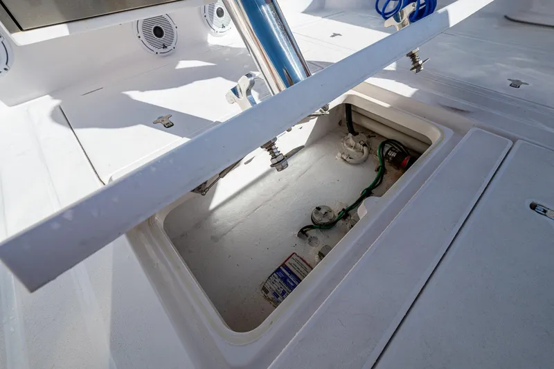 Slide: The Image of 2023 Intrepid 477 Evolution boat storage compartment with open hatch and visible wiring. - 52