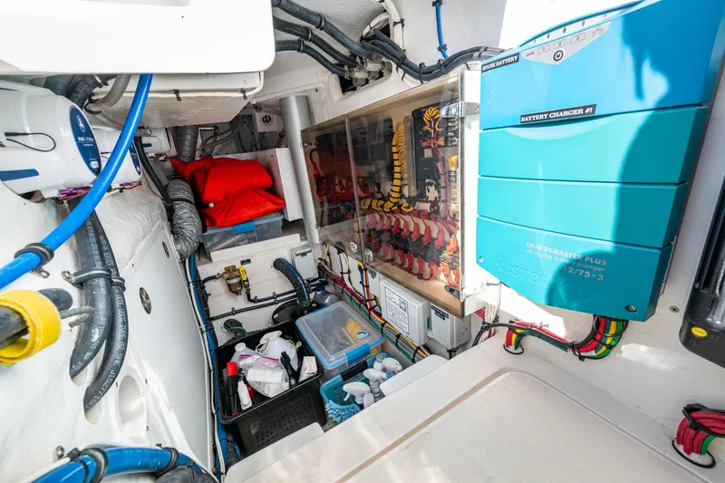 Slide: The Image of 2023 Intrepid 477 Evolution engine room with battery charger and organized wiring. - 65