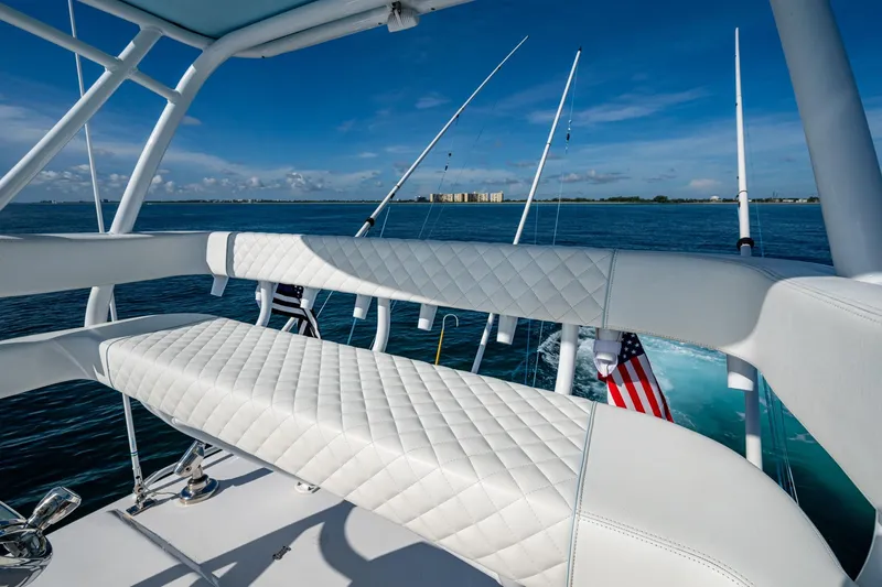 Slide: The Image of 2023 Intrepid 477 Evolution yacht with luxurious seating, ocean view, and fishing rods. - 92