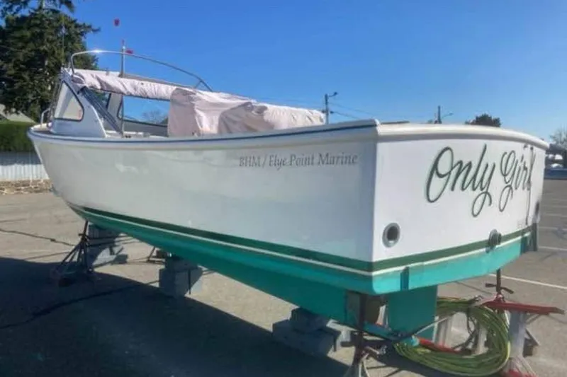 Slide: The Image of 1984 BHM CC Flye Point Launch boat on stands, named "Only Girl," in a sunny outdoor setting. - 4