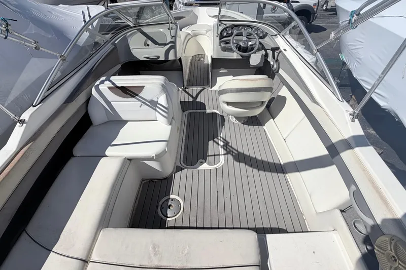 Slide: The Image of 2007 Bayliner 225 boat interior with seating and steering wheel, showcasing spacious layout. - 5