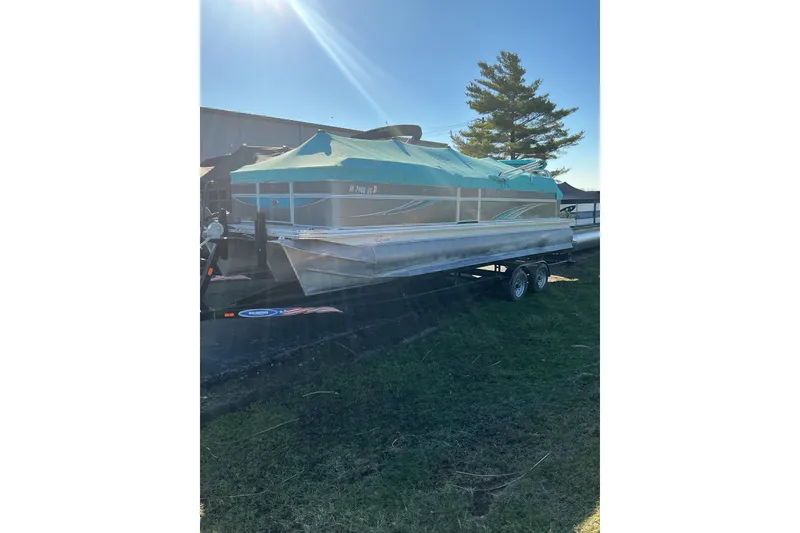 Slide: The Image of 2021 Qwest LS 824 Lanai DS Bar pontoon boat on trailer, covered with green tarp. - 3