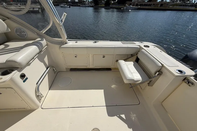 Slide: The Image of 2013 World Cat 290 DC boat interior with seating and storage, overlooking calm waters. - 10