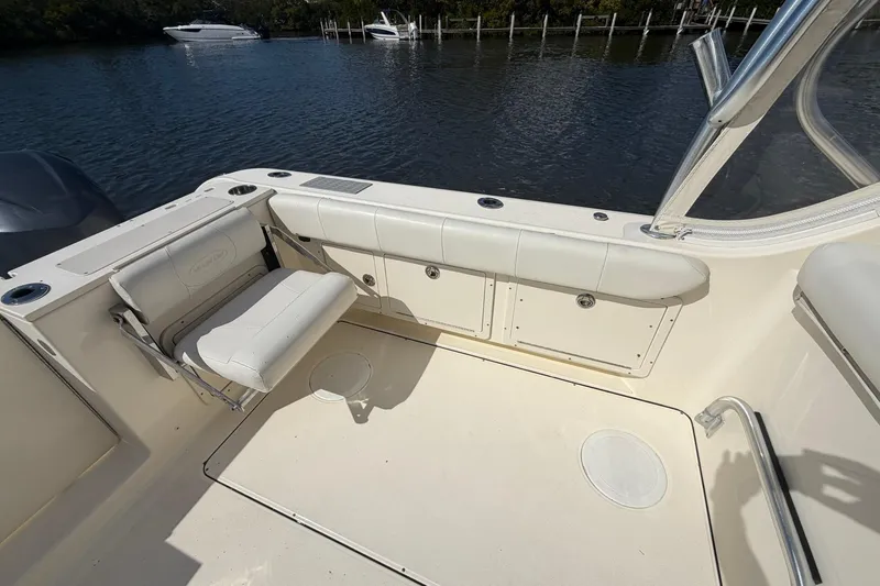 Slide: The Image of 2013 World Cat 290 DC boat interior with seating and storage, docked by the water. - 11