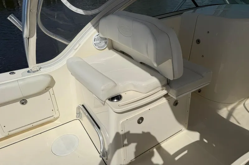Slide: The Image of 2013 World Cat 290 DC boat interior with white seating and storage compartments. - 12