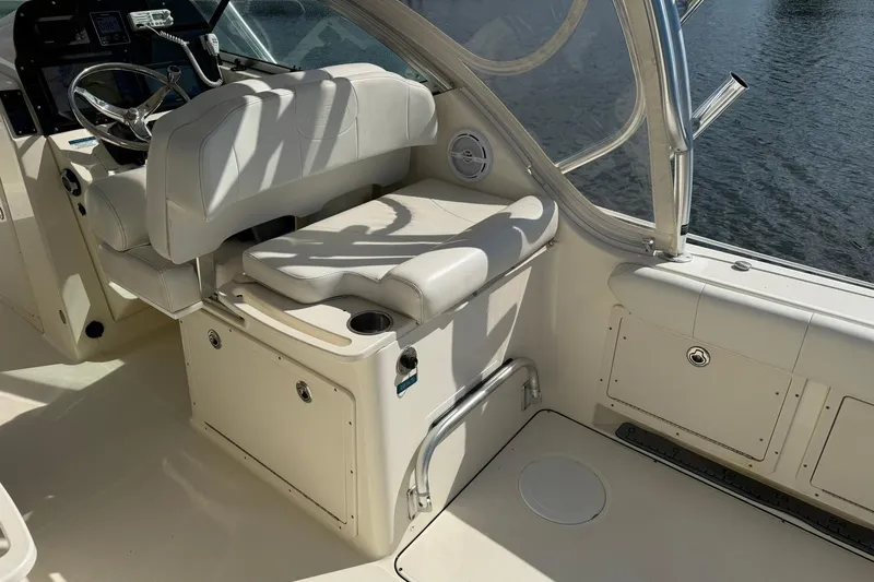 Slide: The Image of Interior of 2013 World Cat 290 DC boat with white seating and steering wheel. - 13