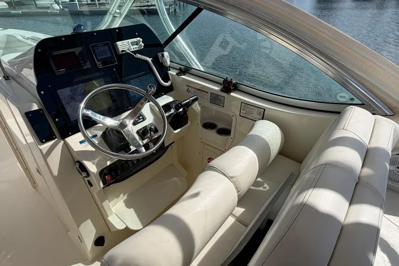 Slide: The Image of 2013 World Cat 290 DC boat cockpit with steering wheel and navigation equipment. - 14